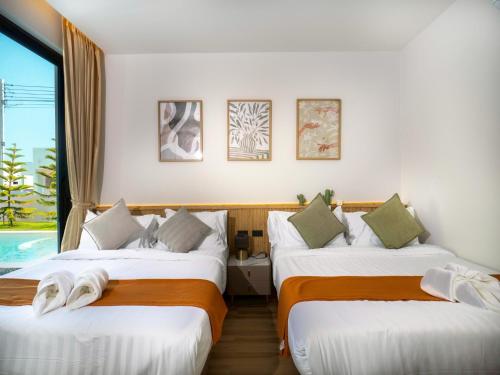 a hotel room with two beds and a window at Hello Teepak A34 in Ban Bo Prakhon