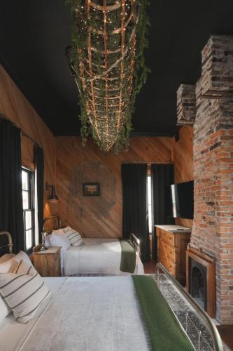a bedroom with two beds and a fireplace and a chandelier at The Gilded Lady - The Cypress Suite in Pensacola