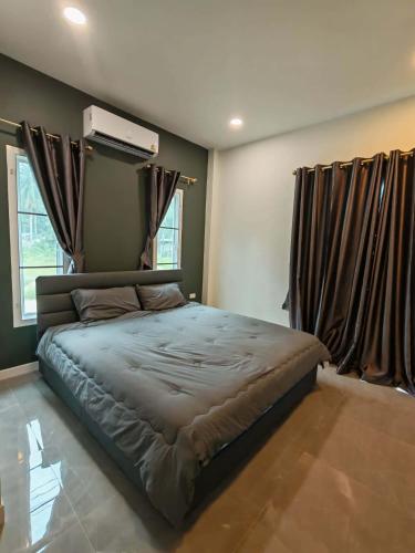 a bedroom with a large bed with brown curtains at jessi house pool in Ban Nok