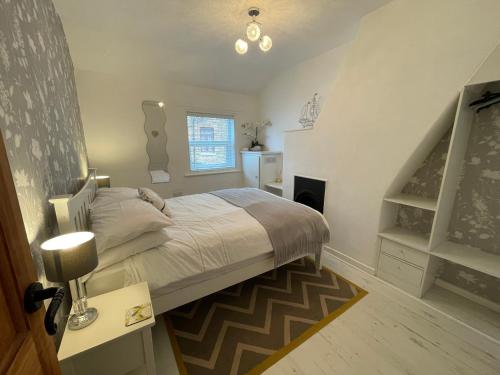 a bedroom with a large bed and a staircase at Trout Cottage in Filey