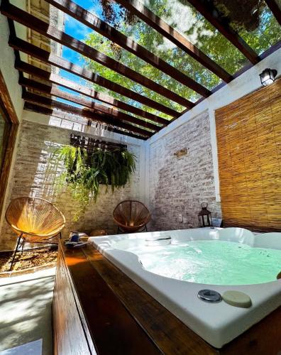 a large bath tub in a room with a large window at Pousada Santa Vila in Serra do Cipo