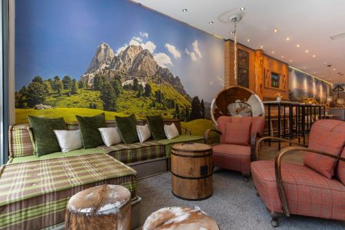 a living room with a couch and a mountain mural at Cocoon München Hauptbahnhof in Munich