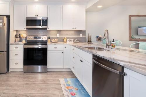 a kitchen with white cabinets and stainless steel appliances at Lighthouse Point 222 in Sanibel