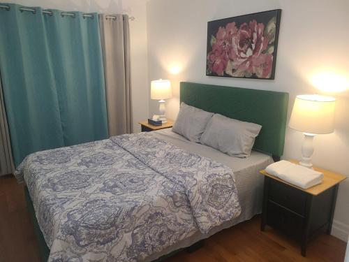 a bed in a room with two lamps and a bed sidx sidx sidx at The Taunton House in Ajax
