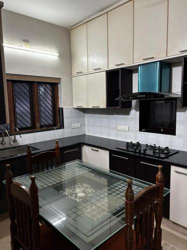 a kitchen with a glass table in the middle at Metro Bliz Alua by thestaypoint in Alwaye