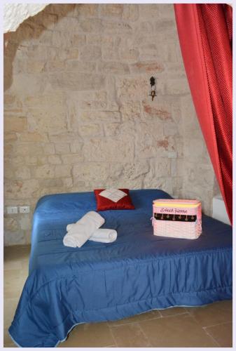 a room with a blue bed with towels on it at Trulli Beauty LAMIA family pool in Martina Franca