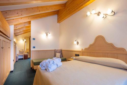 a hotel room with two beds with white sheets at Hotel Crepei in Pozza di Fassa