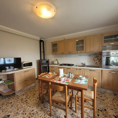 a kitchen with a wooden table with chairs and a tableasteryasteryasteryasteryastery at Il Roseto Mountain Lake Iseo Hospitality in Bossico