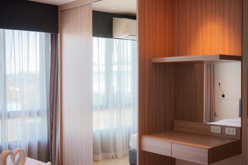 a bathroom with a mirror and a bed and a window at Propify Central Serviced Residence in Ban Ket Ho