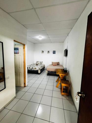 a room with two beds and a room with a door at LA CASONA SV Hostal in La Libertad
