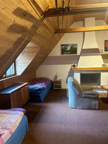 a attic room with two beds and a couch at Hostinec Na hrázi in Hamr na Jezeře