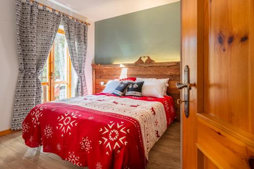 a bedroom with a bed with a red blanket at Residence La Baita in Frassinetto