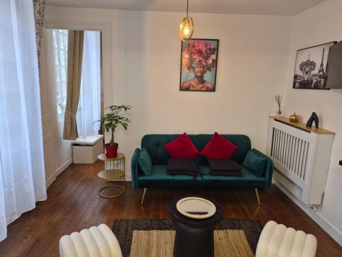 un salon avec un canapé vert et des coussins rouges dans l'établissement Candy house, à Salies-de-Béarn