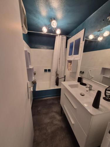 a bathroom with a white sink and a shower at Candy house in Salies-de-Béarn