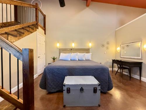 a bedroom with a bed and a staircase with a desk at Haven at Hazel - the Residence in Demorest