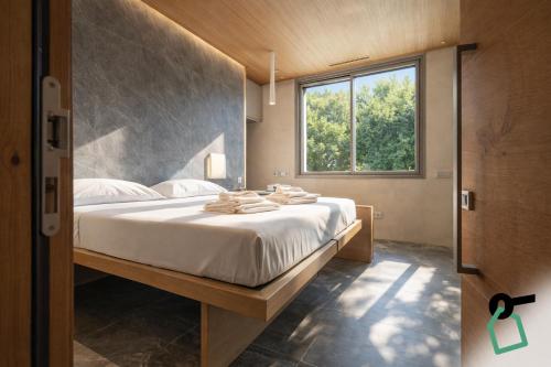 a bedroom with a bed with white sheets and a window at Hotiday Lerici Trebiano in Lerici