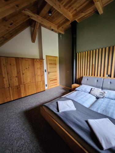 a bedroom with a large bed and a wooden ceiling at Roubenka Panské Pole in Panské Pole