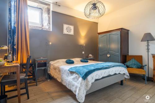 una camera da letto con un letto con cuscini blu sopra di Château Besson a Montluçon