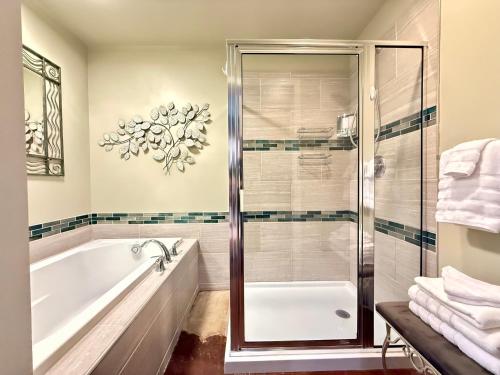 a bathroom with a tub and a glass shower at Haven at Hazel - the Residence in Demorest