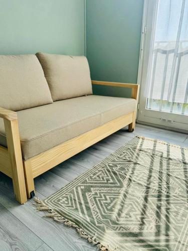 a couch in a room with a rug and a window at Studio, sea side in Berck-sur-Mer