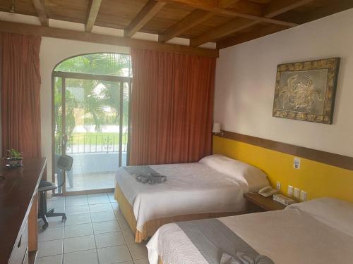 una camera d'albergo con due letti e una finestra di Hotel Pez Vela a Manzanillo