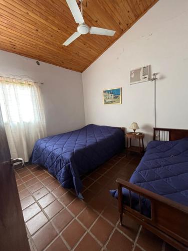 a bedroom with two beds and a ceiling fan at Casa Paso in Paso de la Patria