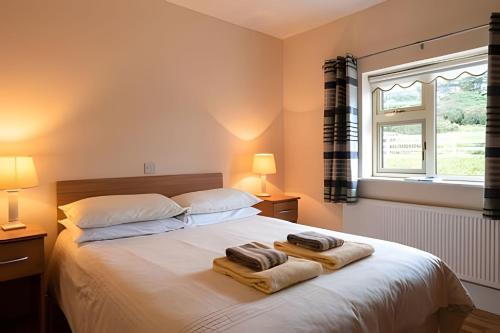 a bedroom with a bed with towels on it at Nancy's Seaside Cottage, Renvyle in Renvyle