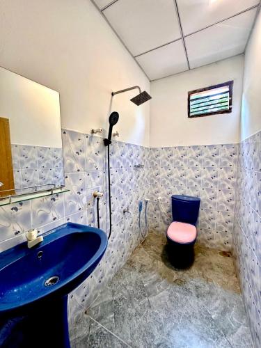 a bathroom with a blue sink and a toilet at The horezt in Kamburugamuwa