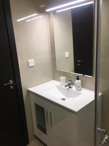 a bathroom with a white sink and a mirror at Para, Descansa, Siente el mar - bienvenido a Cullera in Cullera