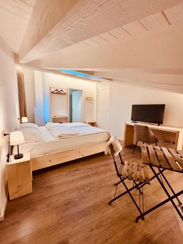 a bedroom with a bed and a desk and a chair at B&B Morbegno in Morbegno