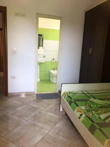 a bedroom with a bed and a bathroom with a tub at The quiet house in Durrës