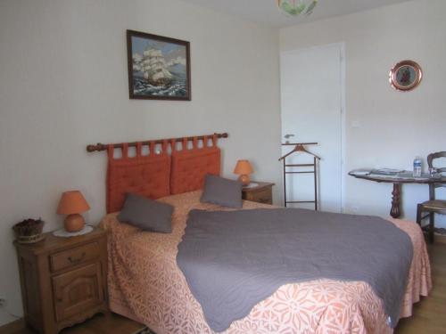 1 dormitorio con 1 cama grande y 1 mesa en La Robinière, en Cerisy-la-Salle