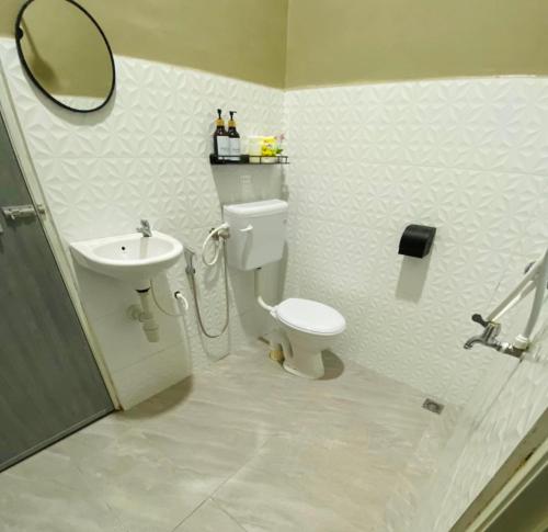 a bathroom with a toilet and a sink and a mirror at Homestay Teratak Nailufar in Pekan