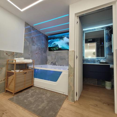a bathroom with a tub and a tv on the wall at TOP1 Templum Luxuriae in Reggio di Calabria