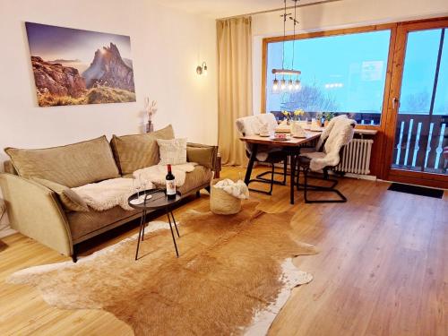 a living room with a couch and a table at Ferienwohnung Allgäuerle 1605 Ski in Ski out an der Skipiste mit Hallenbad Sauna und Tiefgarage in Missen-Wilhams