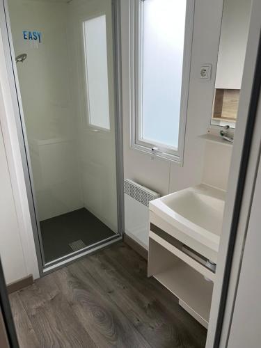 a bathroom with a shower and a sink at Mobil Home Litteau Calvados in Litteau