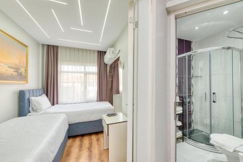 a bedroom with two beds and a glass shower at Bright Apart Hotel in Istanbul