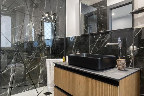 a black bathroom with a sink and a mirror at Magami Station Ciampino in Ciampino