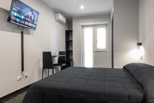 a bedroom with a bed and a flat screen tv at Magami Station Ciampino in Ciampino