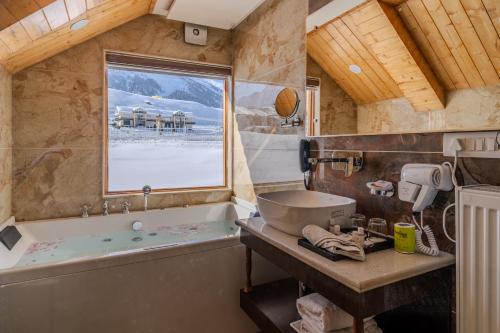 a bathroom with a tub and a sink at Hotel Village Walk in Sonāmarg