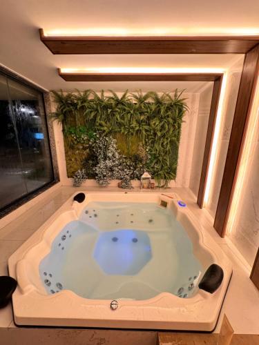 a jacuzzi tub in a room with a plant at Refúgio Serena in Niterói