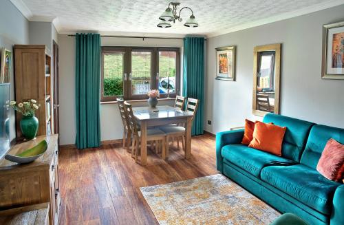 a living room with a blue couch and a table at A cosy house near the city centre in Glasgow