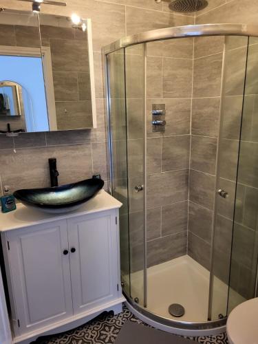 a bathroom with a sink and a shower at Little Brookfield in Lymington