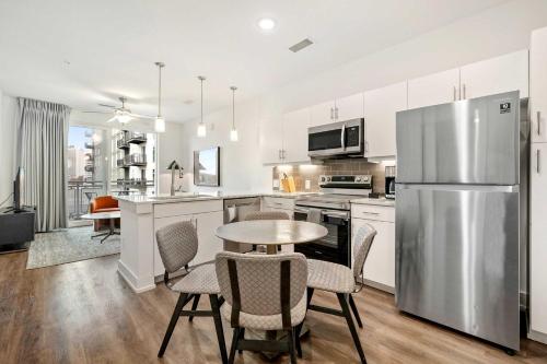a kitchen with a table and a stainless steel refrigerator at 1B1B Midtown Apartment Private Balcony, Views, Gym - 6 in Atlanta