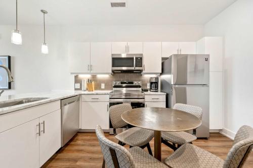 a kitchen with white cabinets and a table and chairs at 1B1B Midtown Apartment Private Balcony, Views, Gym - 6 in Atlanta