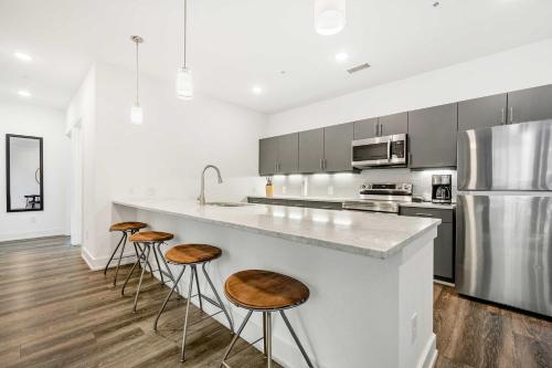 a kitchen with a large counter with stools at 2B2B with Private Balcony Modern & Stylish - 2B4 in Atlanta