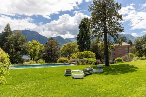a garden with a swimming pool and mountains in the background at Villa Artemisia by MyVillaCollection in Lenno