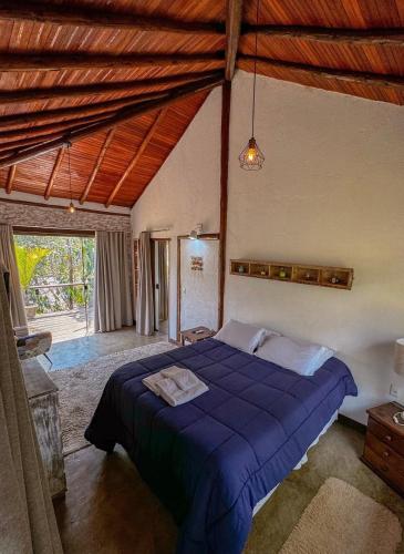 a bedroom with a blue bed in a room at Pousada Santa Vila in Serra do Cipo