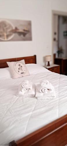 a bed with white sheets and two folded towels at Orlando House 1975 in Montecchio