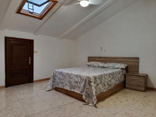 a bedroom with a bed and a ceiling with a window at Atico Marin playa in Marín